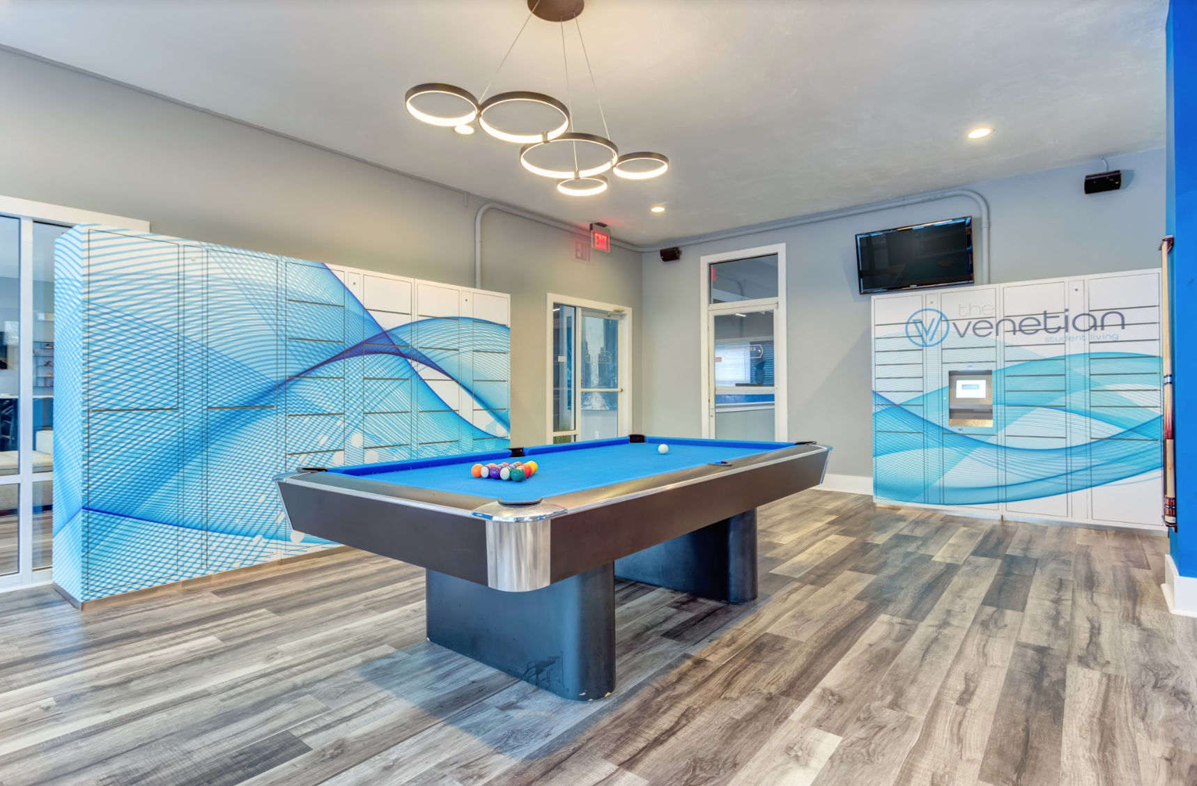 Interior photograph of student living clubroom with pool table and package lockers