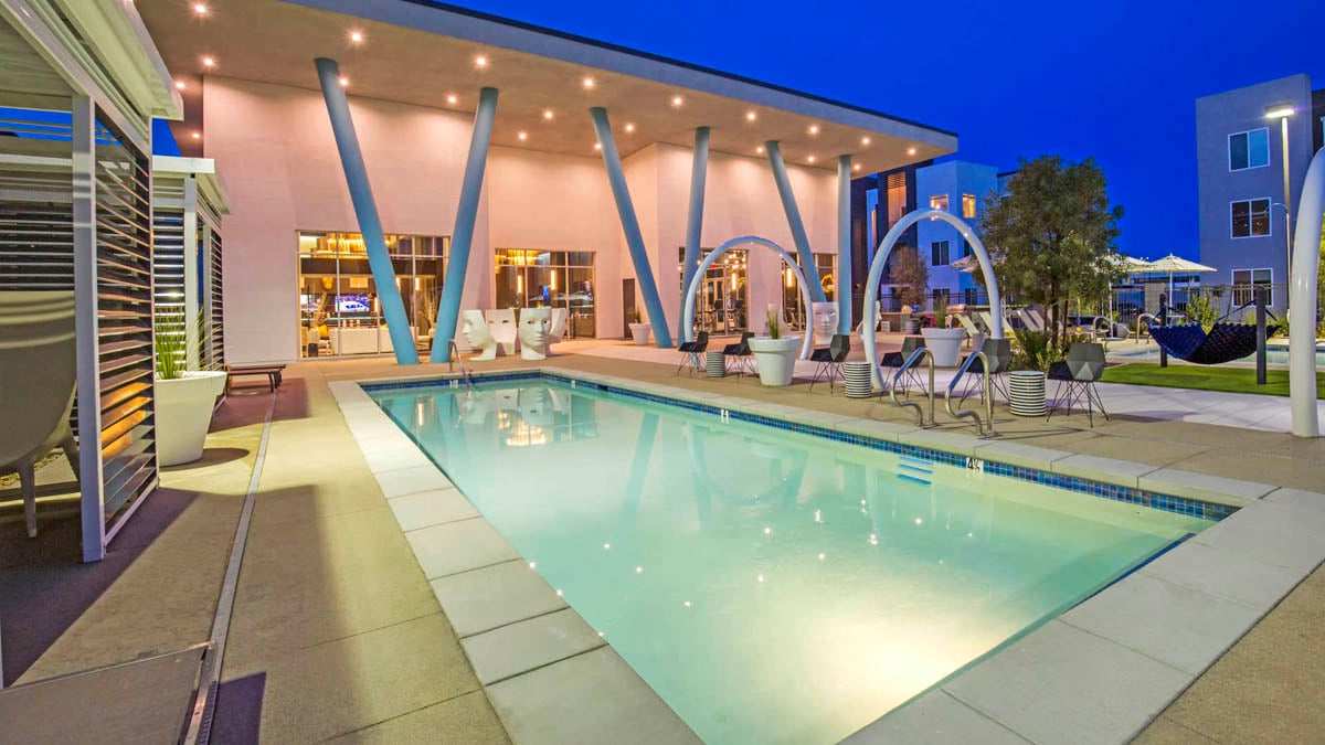 Exterior twilight photograph of an apartment community pool