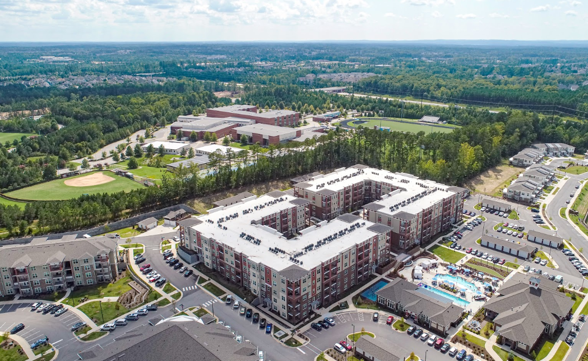 Exterior drone photograph of an apartment community building