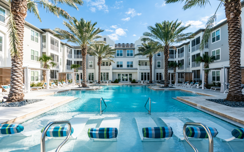 Professional photography of a swimming pool area at an apartment complex during the day