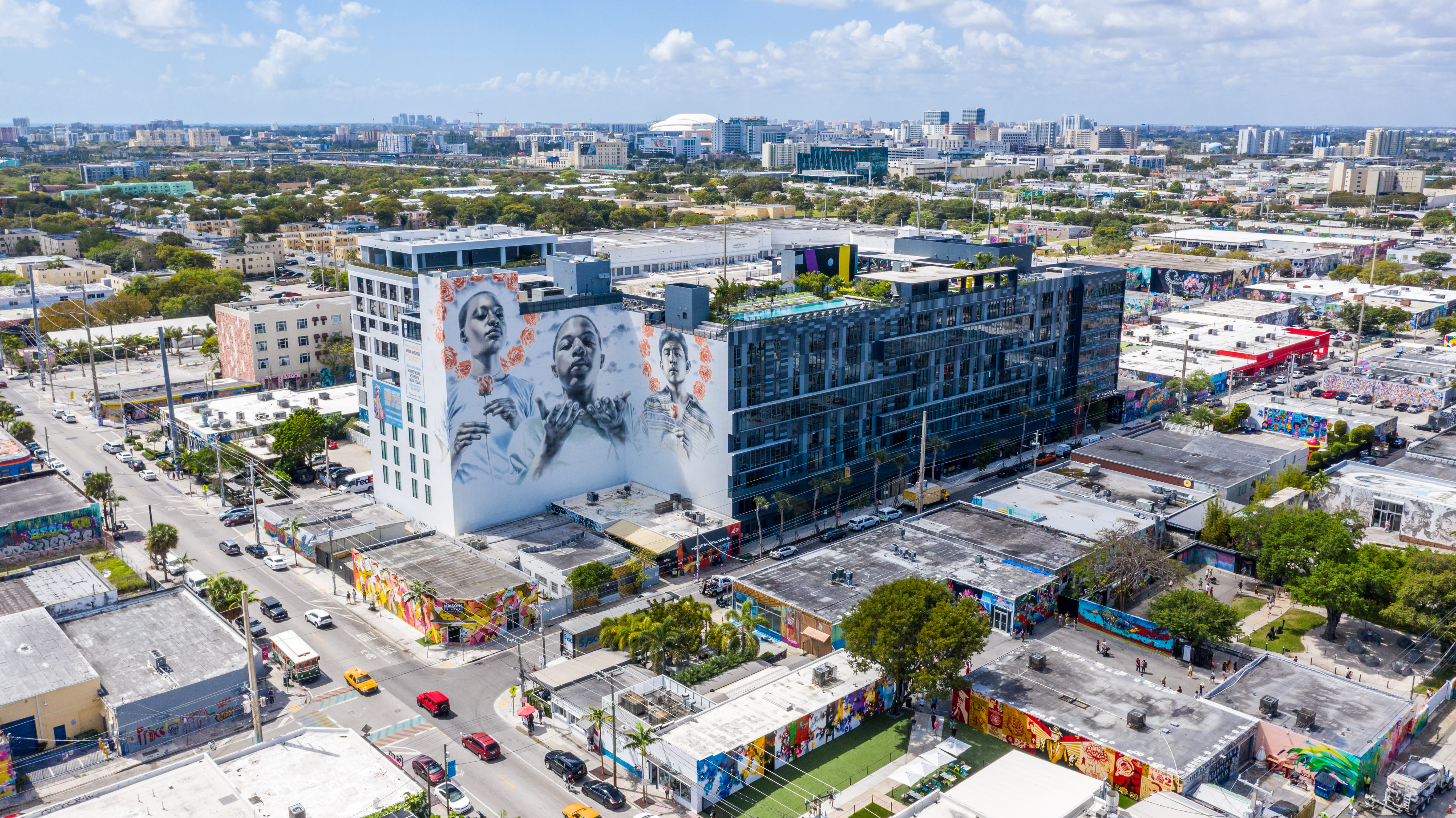 Exterior drone photograph of an apartment building with a mural