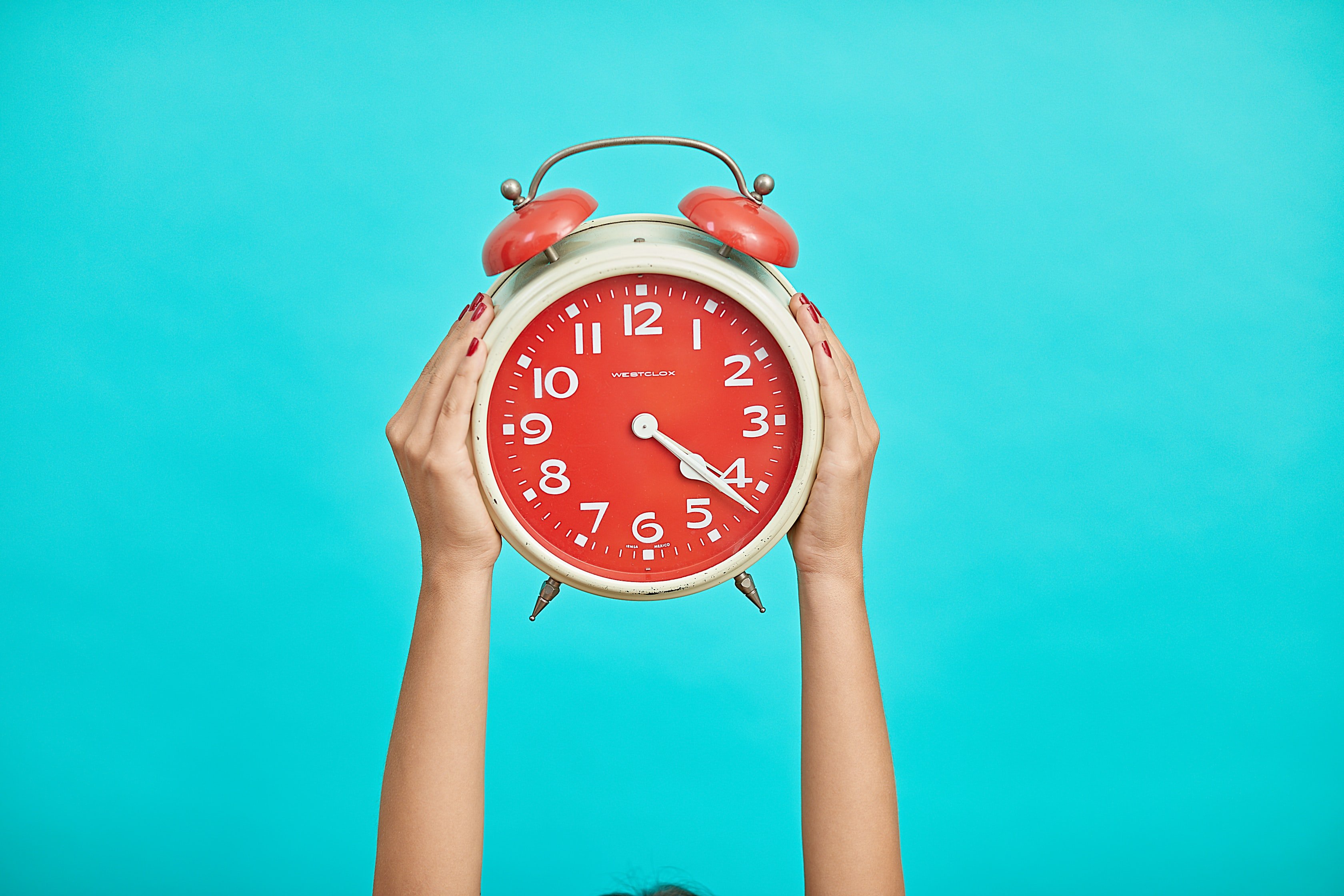 hands holding clock in the air